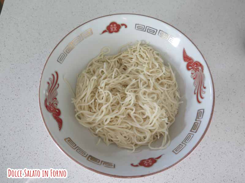 Due ciotole di ramen con una ciotola viola di noodles.