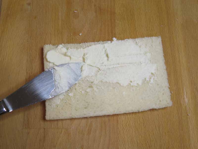 spalma formaggio sulla seconda fetta di pane