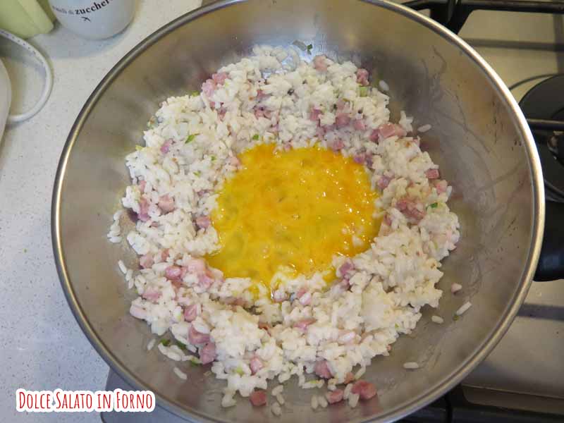 Versa l'uovo nella conca di riso